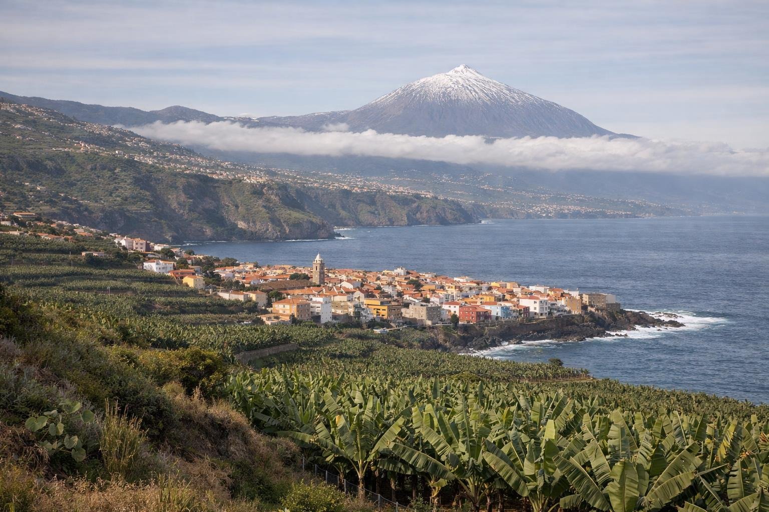 Grüne Nordküste Teneriffas mit Altstadt am Meer und dem Teide über den Wolken